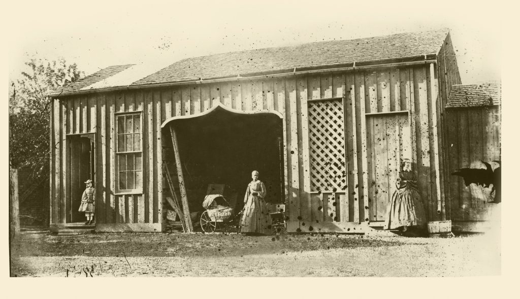 The University of Mississippi Carriage House and an (assumed) domestic servant, collodion glass plate negative by Edward C. Boynton, a professor of chemistry, minerology, and geology from 1856–1861. Courtesy of the University of Mississippi Department of Archives and Special Collections.